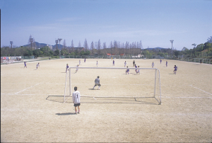広々としたグラウンドでサッカーをしている神戸総合運動公園球技場の様子の写真